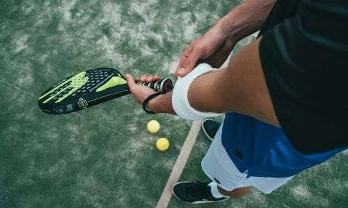 advance pickleball paddle with a bunch of balls in the court