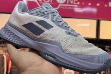 a person holding Babolat Jet Mach 3 shoe in his hand