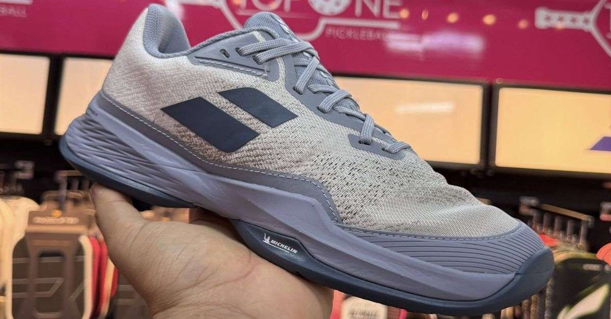 a person holding Babolat Jet Mach 3 shoe in his hand