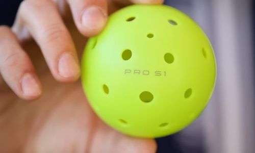 a person holding Selkirk Pro S1 outdoor pickleball ball